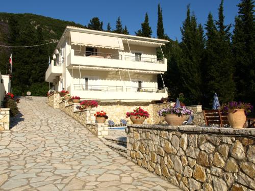 a building with potted plants on a stone wall at Geni Garden Apartments in Yenion