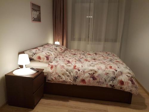 a bedroom with a bed and a lamp on a night stand at Solankowa Aleja in Inowrocław
