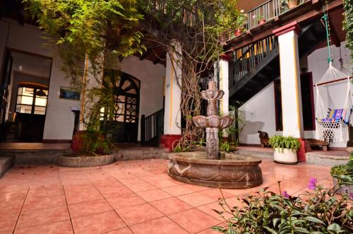 a courtyard with a fountain in the middle of a building at Hostal Riviera Sucre in Otavalo