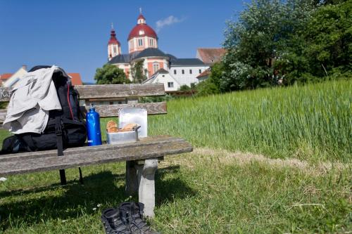 a park bench with a backpack and a bag on it at Hotel-Restaurant Gruber in Pöllau