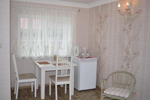 エレツにあるLada Hotelのキッチン(白いテーブル、椅子付)、窓