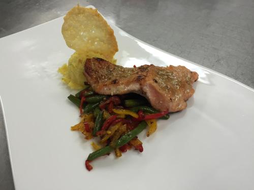 a white plate with meat and vegetables and chips at Hotel-Restaurant Gruber in Pöllau