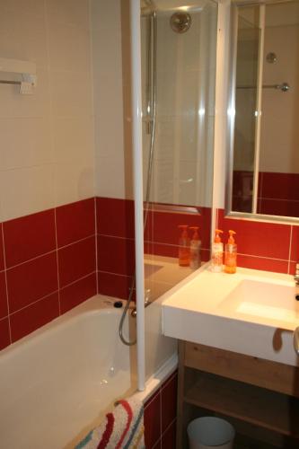 ein Badezimmer mit Badewanne, Waschbecken und Spiegel in der Unterkunft Le Britania 507 in La Tania