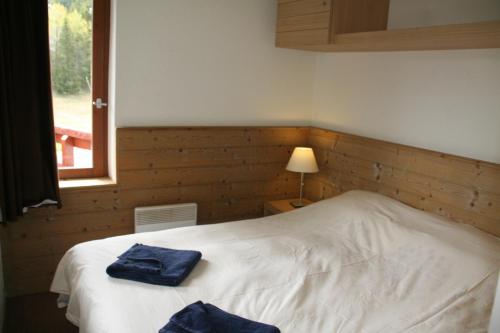 ein Schlafzimmer mit einem Bett mit zwei blauen Handtüchern darauf in der Unterkunft Le Britania 507 in La Tania