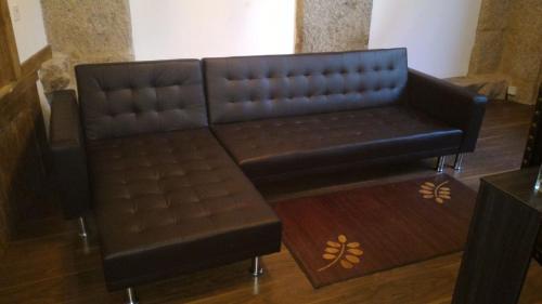 un sofá de cuero marrón sentado en una habitación en Loft Medieval, en Ribadavia