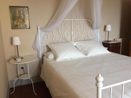 a bedroom with a white bed and a table at La casina del Poggio in Ponticino