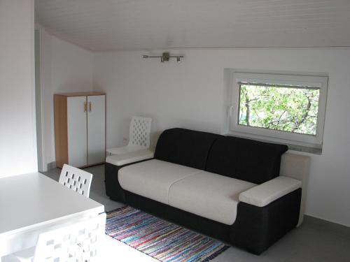 a living room with a couch and a window at Apartma Furlan in Štanjel