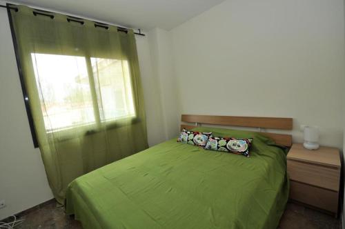 リョレート・デ・マルにあるApartment Mariposaのベッドルーム(緑のベッド1台、窓付)