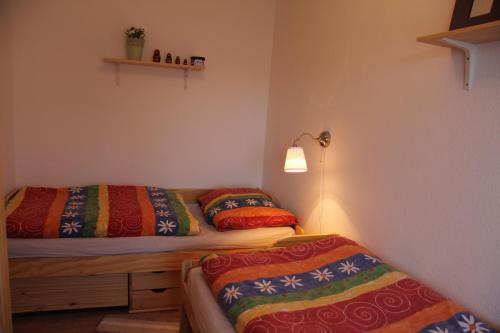 a bedroom with two beds with colorful blankets at Kleine Seenadel in Dornumersiel