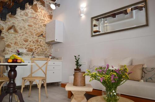 een woonkamer met een bank en een tafel met bloemen bij Casa al Bocca del Porto in Chania