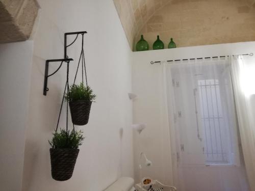 two plants in baskets on the wall of a bathroom at Suite Al Ponte in Taranto