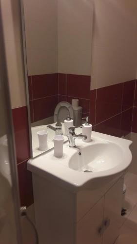 a bathroom with a white sink and a mirror at Apartmani Vitturi in Kaštela
