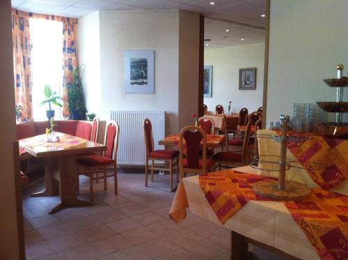 a dining room with tables and chairs in a restaurant at Landhotel Am Peetscher See in Mirow