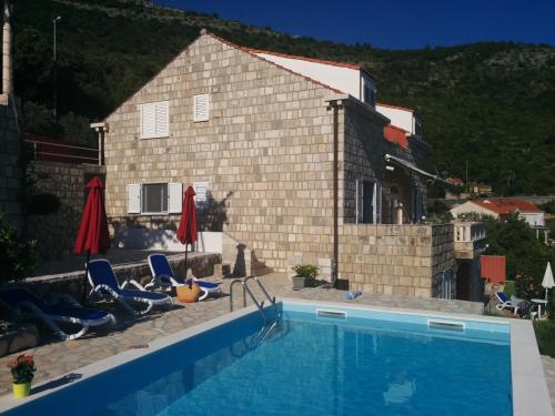 a swimming pool in front of a house at Apartments Anamaria in Dubrovnik