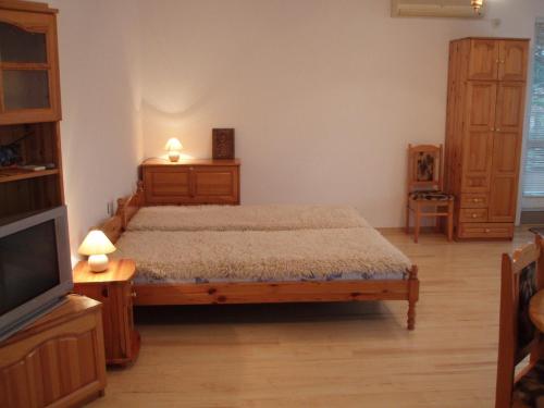 a bedroom with a bed and a flat screen tv at Georgievi Guest House in Kalofer