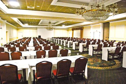 a large banquet hall with white tables and chairs at Ramada by Wyndham Seekonk Providence Area in Seekonk