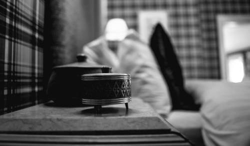 a table with a pot and a person in the background at Tir y Coed Country House in Conwy