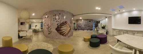 a lobby with tables and chairs and a wall at Globetrotter Hostel in León
