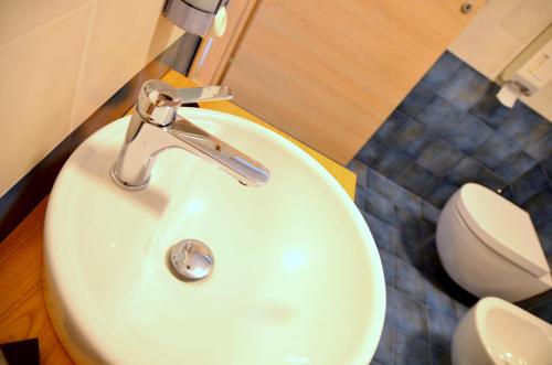 a bathroom with a white sink and a toilet at La Casa del Melograno in Santa Venerina