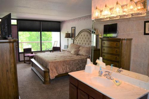 a bedroom with a bed and a sink and a mirror at Rivergate Mountain Lodge in Pigeon Forge