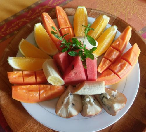 a plate of fruit and vegetables on a table at Polish Princess Guest House in Port Antonio