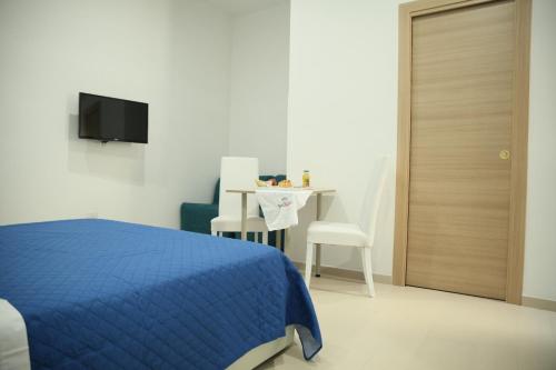 a bedroom with a blue bed and a table and chair at Il Gioiellino Lifestyle in Naples