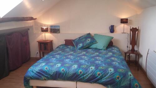 une chambre avec un lit avec une couette bleue dans l'établissement Gîte Orus, à Orus