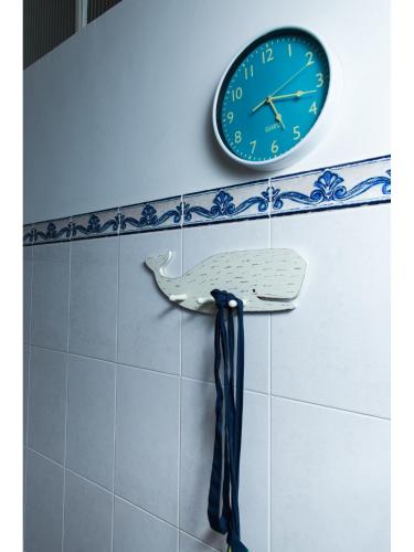 a clock and a tie hanging on a wall at Downtown Shelter - Casa da Praça in Aveiro