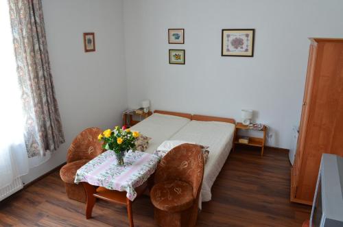 a bedroom with a bed and a table with flowers on it at Dom Gościnny "Berberys" in Rewal