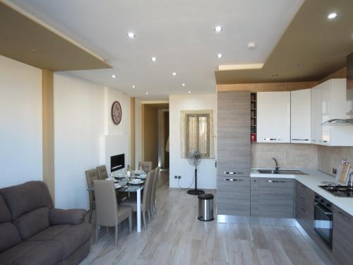 uma cozinha e sala de estar com um sofá e uma mesa em The Ivies em Mosta