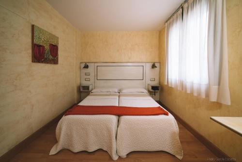 1 dormitorio con 2 camas en una habitación con ventana en Hotel Castillo de Javier en Pamplona