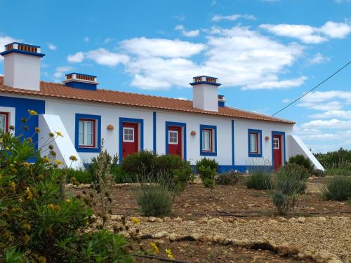 a blue and white house with red doors at Vales do Alentejo in Bicos