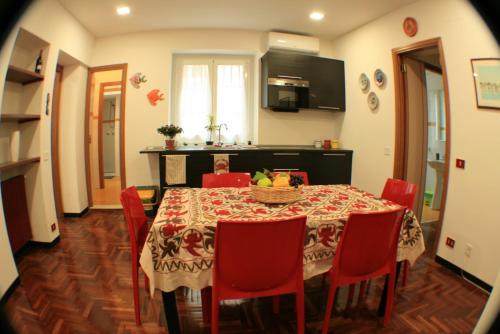 kuchnia i jadalnia ze stołem i czerwonymi krzesłami w obiekcie Appartamento Politeama w mieście Palermo