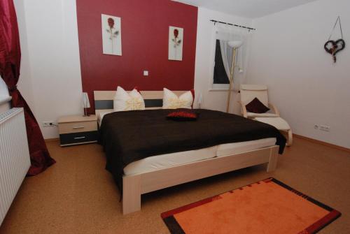 a bedroom with a bed and a red wall at Ferienwohnungen Martensstrasse in Gersfeld