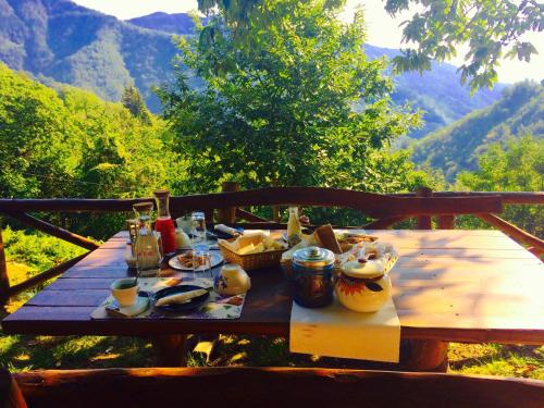 B&B La Presa في Molino del Pallone: طاولة خشبية عليها طعام مع جبال في الخلف