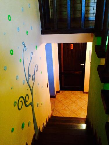 a stairway with a mural of a tree on the wall at B&B La Presa in Molino del Pallone
