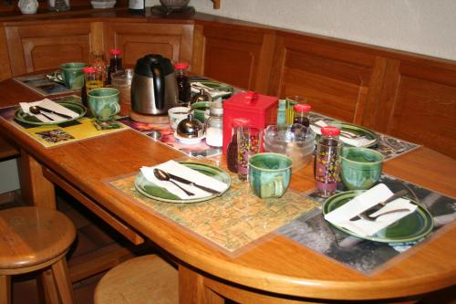 a wooden table with plates and dishes on it at BnB Claudy et Elizabeth Michellod-Dutheil in Le Châble