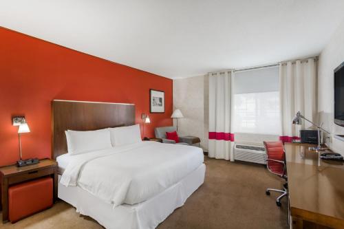 a hotel room with a large bed and a television at La Hacienda San Jose Silicon Valley in San Jose