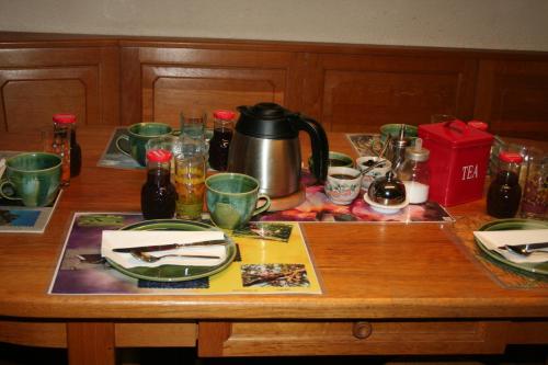 a wooden table with a tea pot and dishes on it at BnB Claudy et Elizabeth Michellod-Dutheil in Le Châble