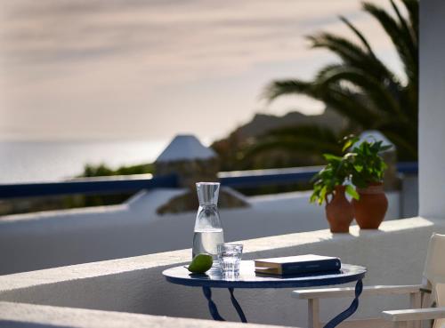 a table with a glass vase and a book at San Marco Hotel and Villas in Houlakia