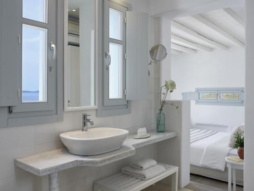 a white bathroom with a sink and a bed at San Marco Hotel and Villas in Houlakia