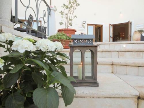 a lantern sitting on the steps next to a plant at Hotel Brancamaria in Cala Gonone