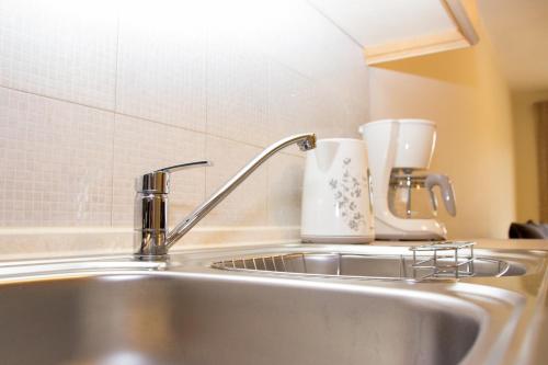 a kitchen sink with a faucet and a cup at Keramoti Luxury Apartments in Keramoti