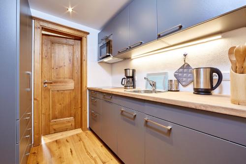 eine Küche mit einem Waschbecken und einer Holztür in der Unterkunft Ferienwohnung Graseck in Garmisch-Partenkirchen