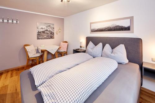 a bedroom with a bed and a table with chairs at Ferienwohnung Graseck in Garmisch-Partenkirchen