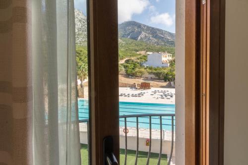 a view of a beach from a window at Hotel Brancamaria in Cala Gonone