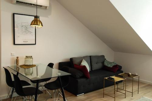 uma sala de estar com um sofá preto e uma mesa em Cracovia em Cracóvia