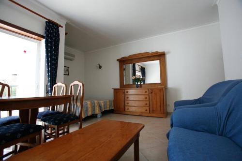 a living room with a blue couch and a table at Apartamentos Coral do Vau in Portimão