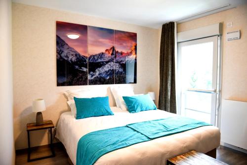 サランシュにあるAppartement au pied du Mont-Blanc !のベッドルーム1室(壁に絵画が描かれたベッド1台付)