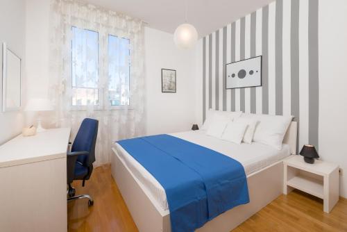 Habitación blanca con cama azul y escritorio. en City Center Apartment Good Life, en Split